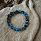 Blue beaded bracelet on a textured beige surface