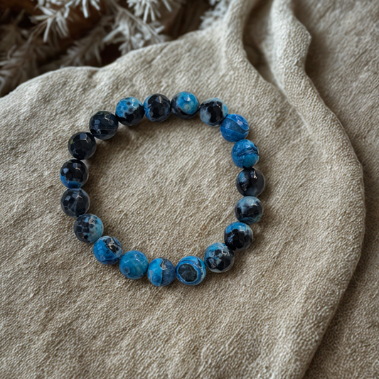 Blue beaded bracelet on a textured beige surface