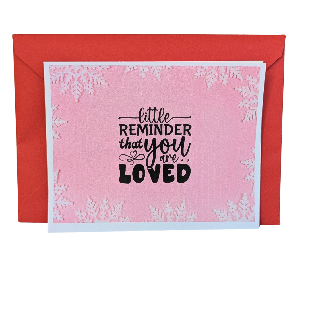Pink card with text 'little reminder that you are loved' and red envelope